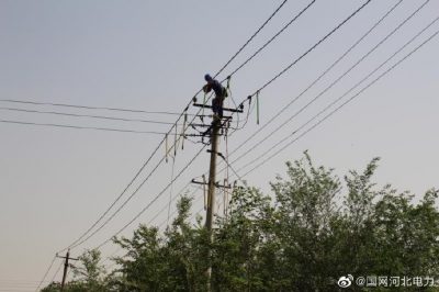 施工人員走進深澤縣10千伏613橋頭線42號桿架設(shè)導線